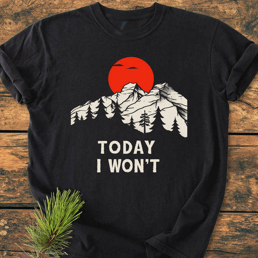 Black long-sleeve tee 1423 Today I Won't with snow-capped mountains, pine trees, and red sun graphic, laid on wooden surface, embodying a vintage, lived-in look for everyday adventures.