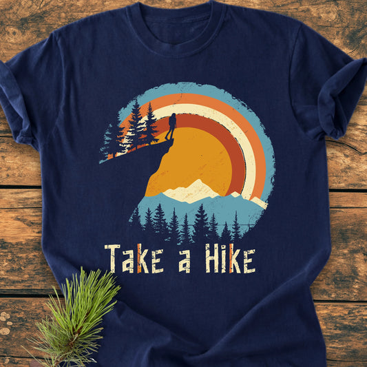 Take A Hike - Vintage Wash Tee featuring a retro outdoor scene with a hiker and mountains. Laid flat, showcasing relaxed unisex fit and vintage-style slogan, perfect for everyday wear.
