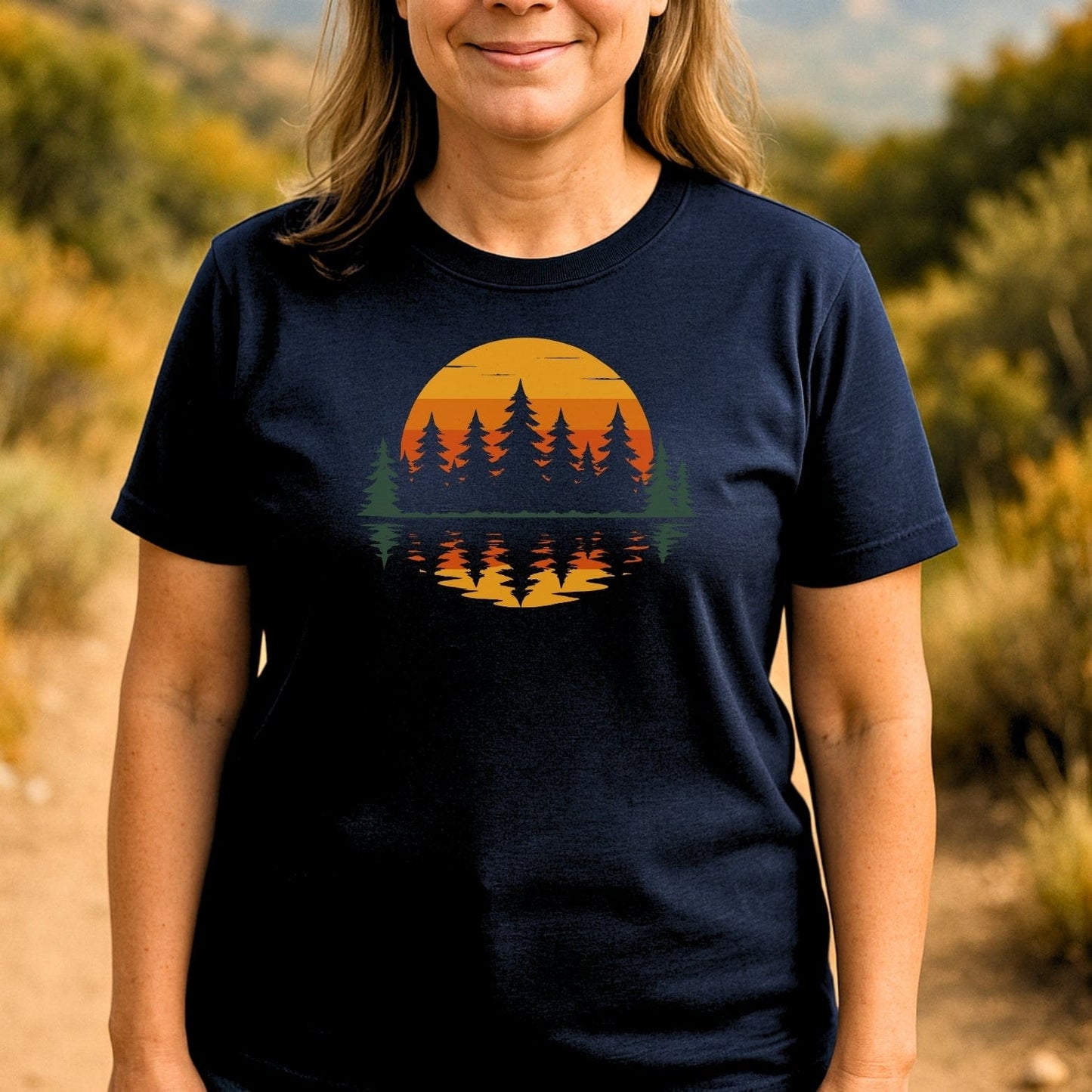 Retro Sunset Pines T-Shirt featuring a stylized sunset and evergreen trees graphic, worn outdoors, showcasing comfort and durability for everyday adventure.