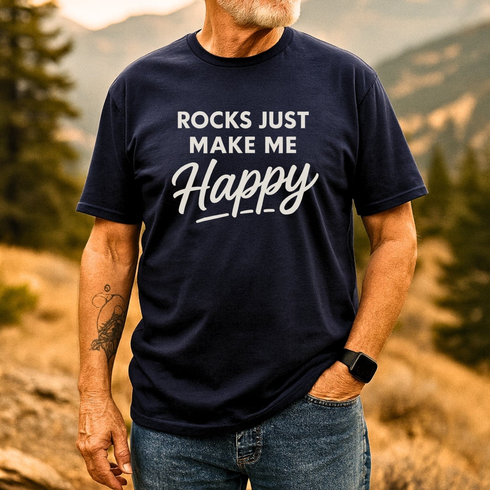 Person outdoors wearing a Rocks Make Me Happy T-Shirt, showcasing durable print and comfortable fit, paired with jeans and a smartwatch.