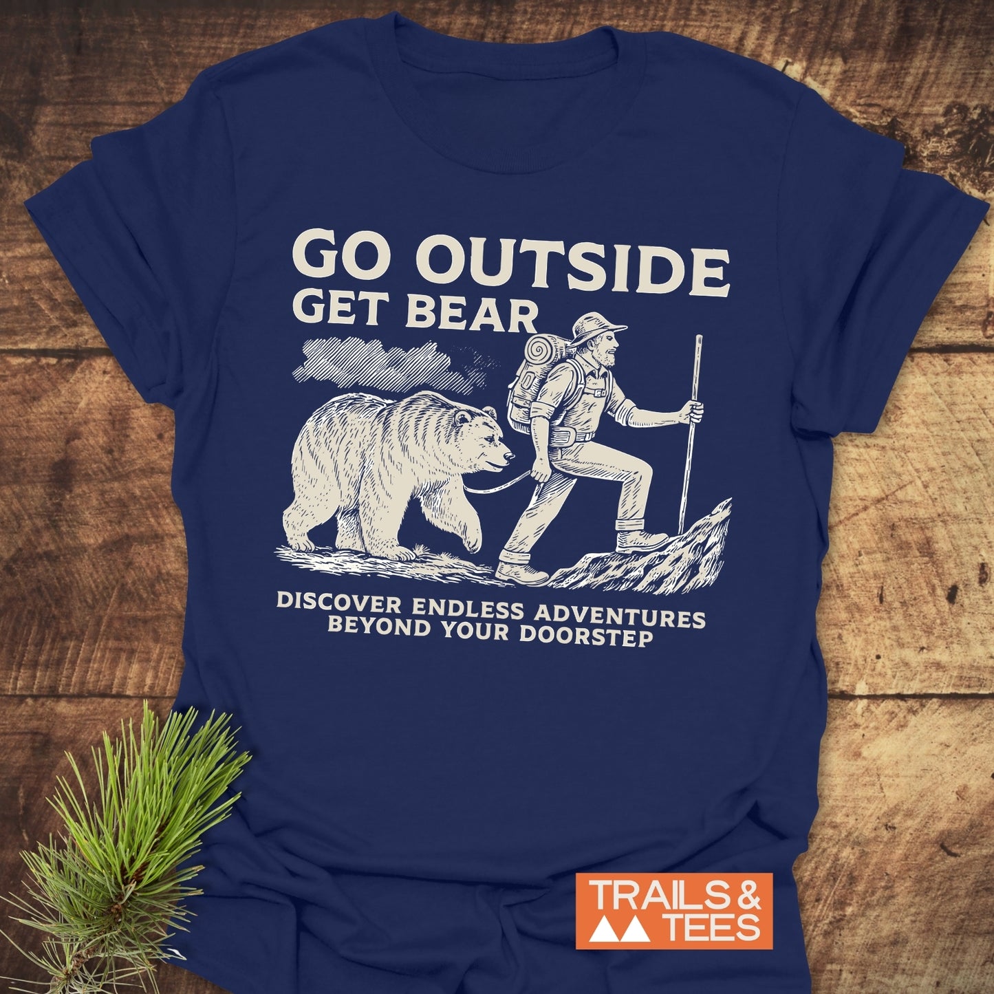 Man wearing Go Outside Get Bear T-Shirt, featuring a playful graphic of a man walking a bear, highlighting an active lifestyle theme.