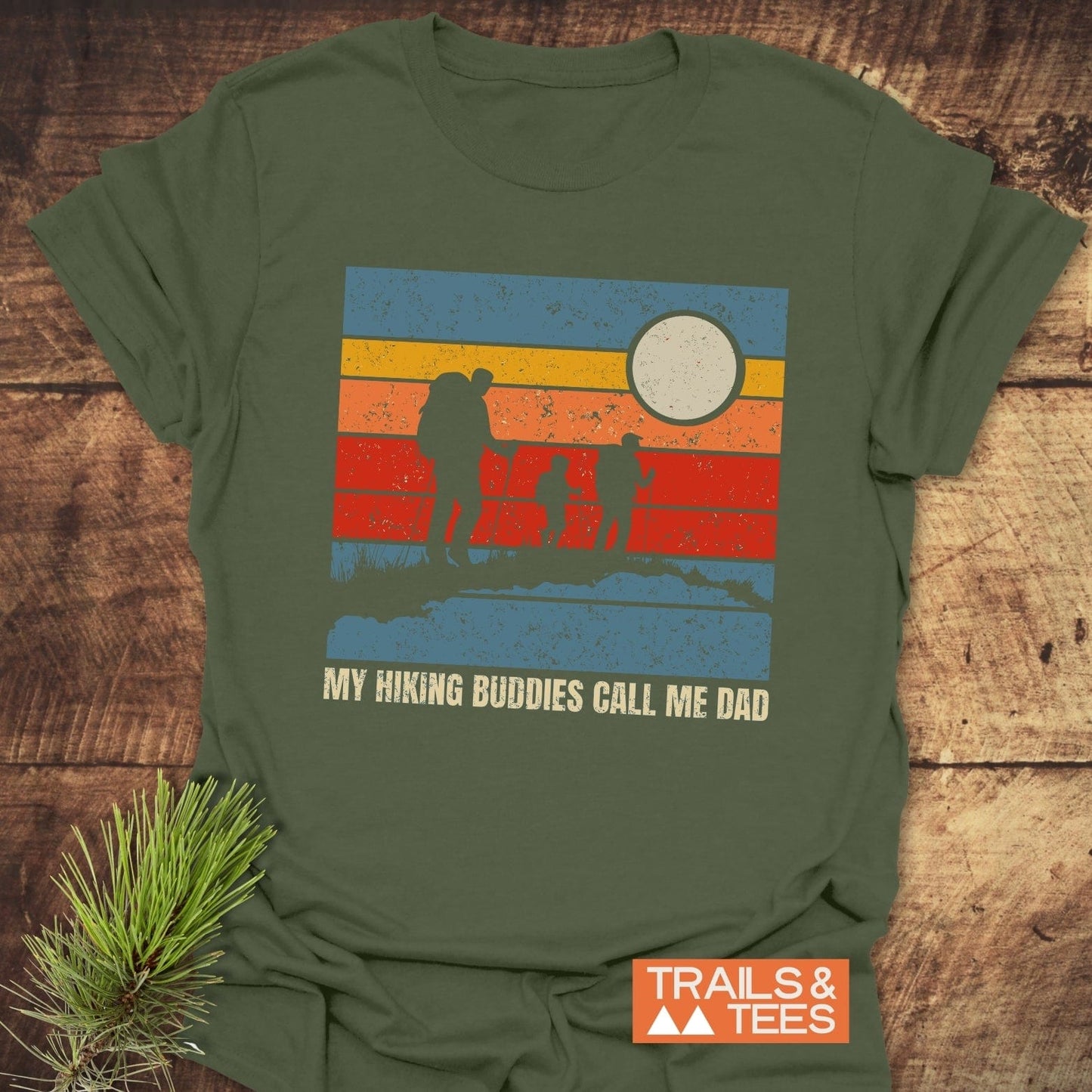 My Hiking Buddies Call Me Dad T-Shirt featuring silhouettes of a person and images of people, highlighting an adventurous family theme.