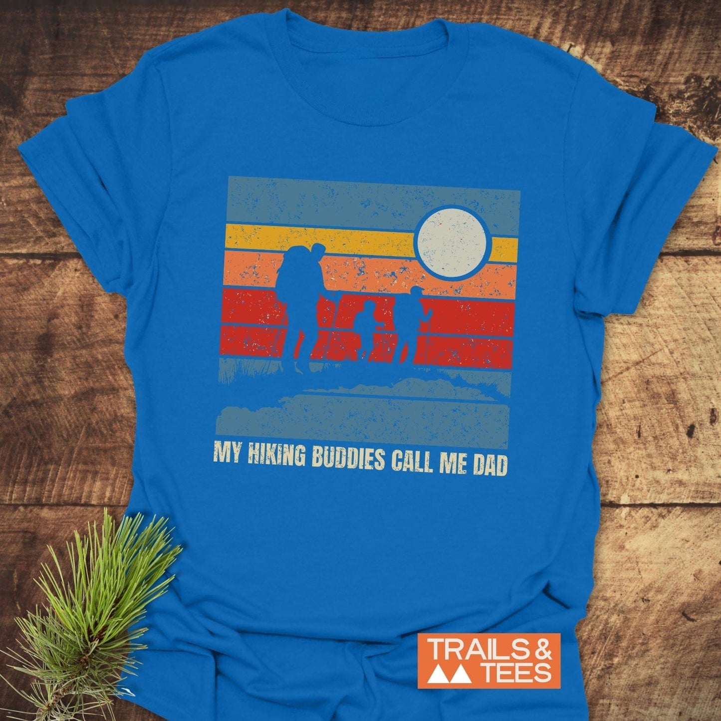 My Hiking Buddies Call Me Dad T-Shirt displayed with a close-up of a blue sign featuring the shirt's playful, adventure-themed text design.