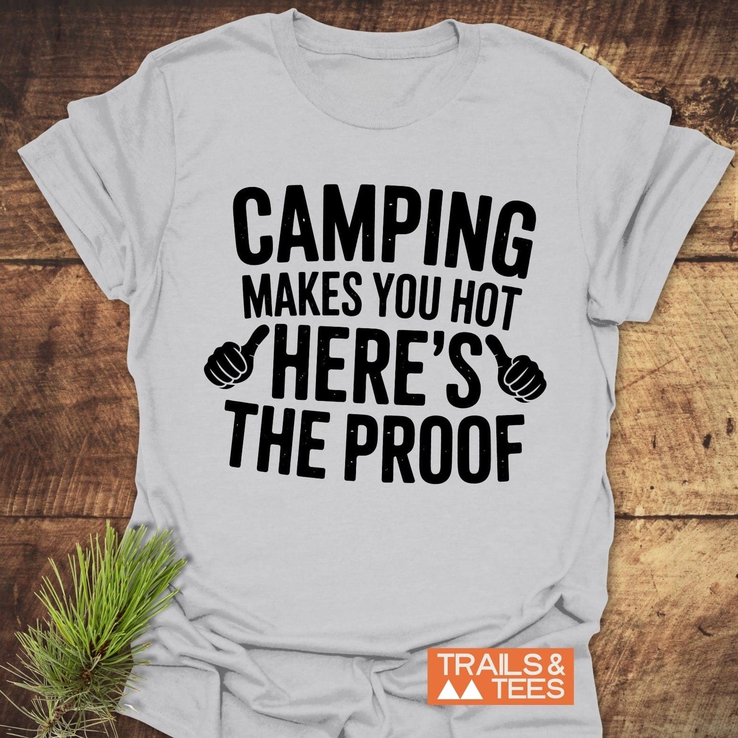 Close-up of the Camping Makes You Hot T-Shirt, featuring bold black text on a white fabric, ideal for outdoor enthusiasts.