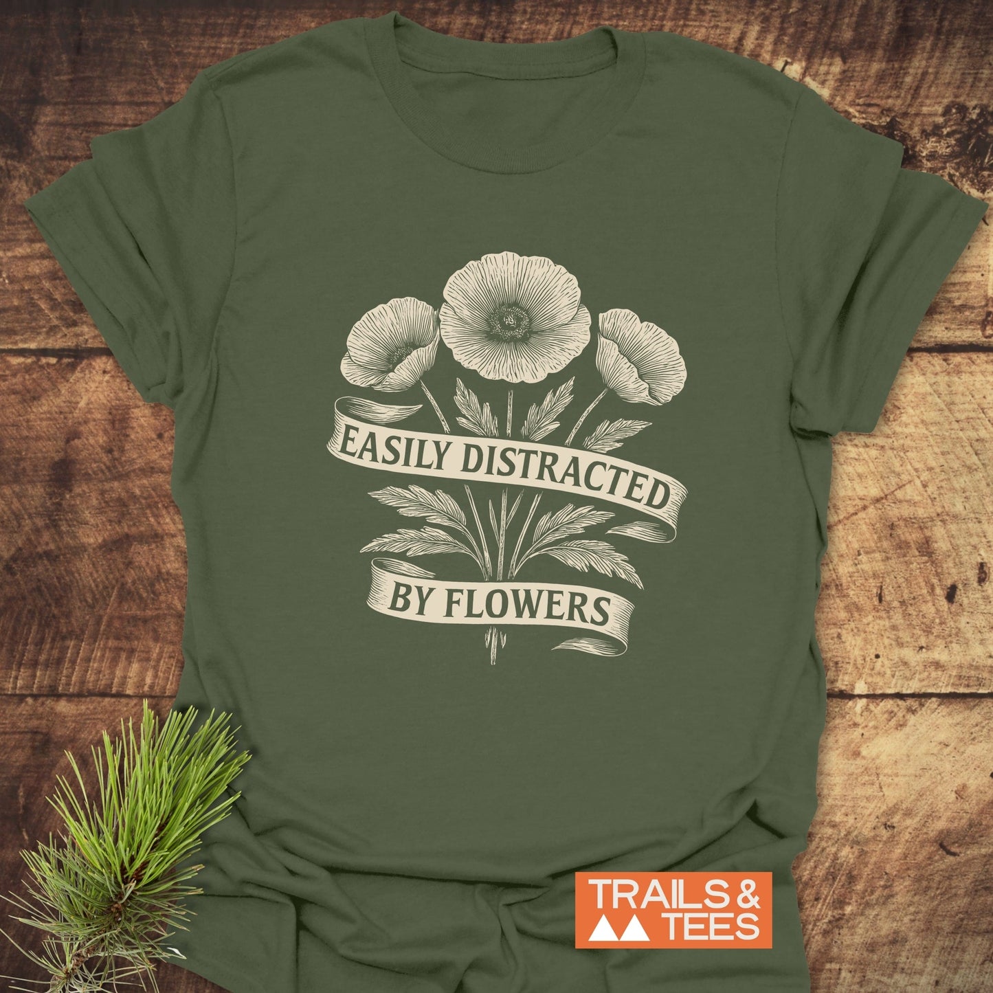 Close-up of the Easyly Distracted By Flowers T-Shirt, featuring white flower prints on a green background, made from lightweight, durable ring-spun cotton.