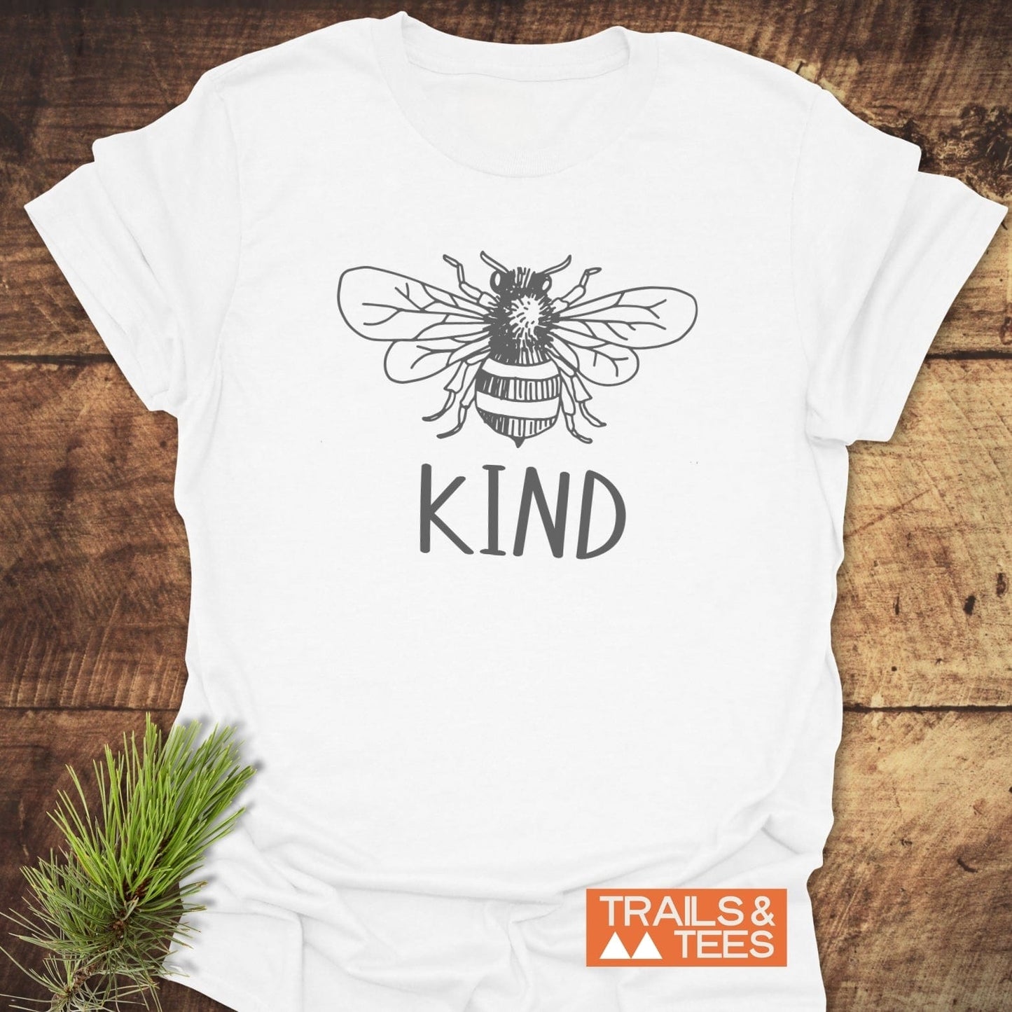 Close-up of the Bee Kind T-Shirt featuring a black and white bee drawing, crafted from soft ring-spun cotton, designed for outdoor adventures.