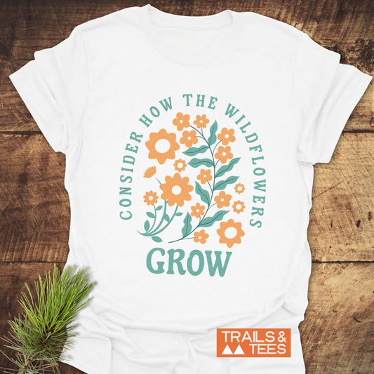 Wildflowers Luke 12:27 T-Shirt featuring orange floral design and green text, crafted from soft ring-spun cotton for comfort and durability, perfect for outdoor adventures.