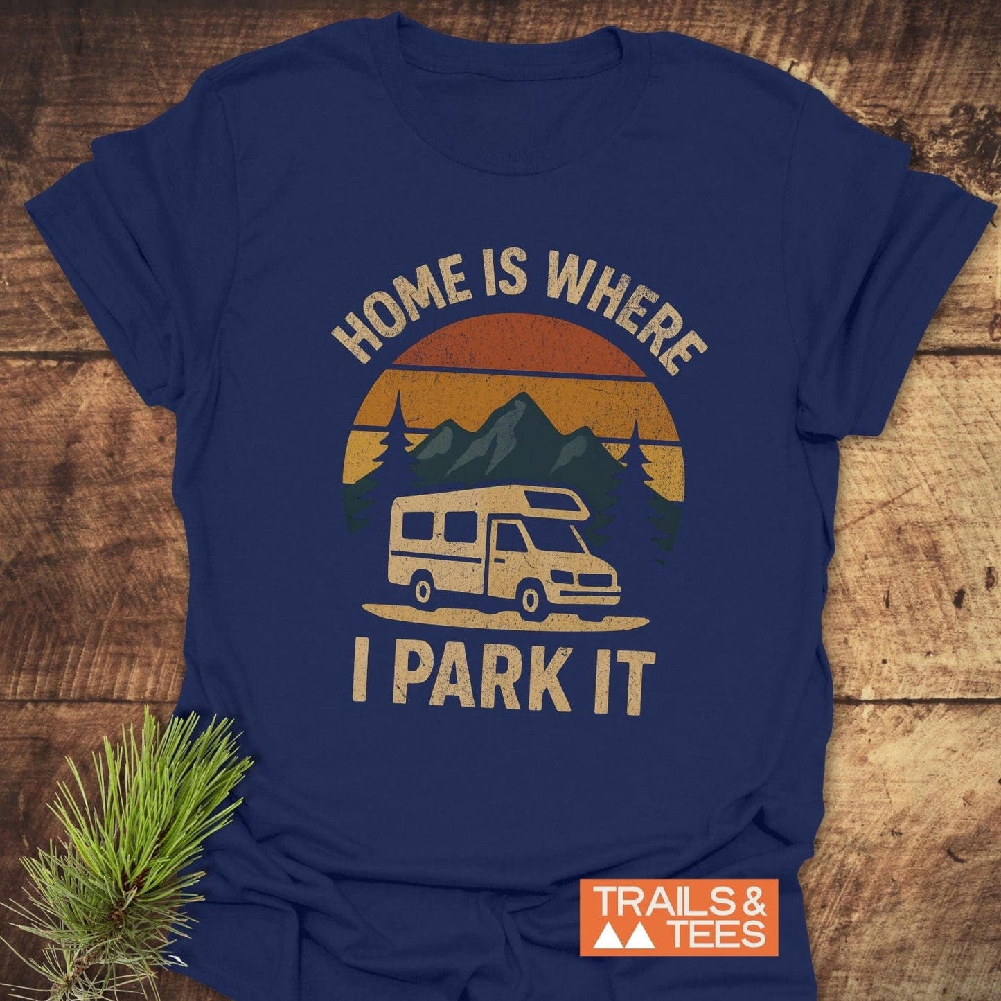 Home Is Where I Park It T-Shirt features a van, mountains, and pine branch design, crafted for comfort and adventure with durable, pre-shrunk cotton.