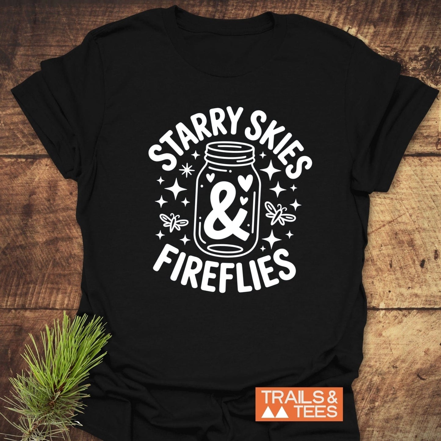 Close-up of the Starry Skies & Fireflies T-Shirt, featuring white text on a black active shirt, highlighting the logo and design details.