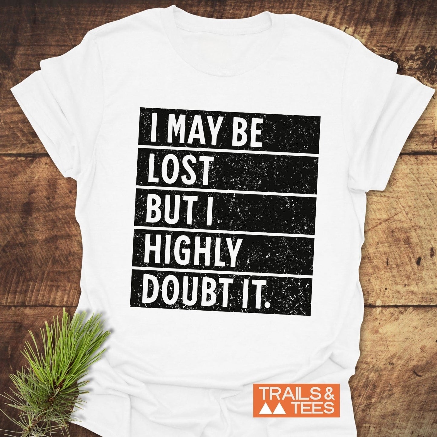 Close-up of the I May Be Lost But I Highly Doubt It T-shirt, featuring bold white text on a black background, emphasizing the playful message.