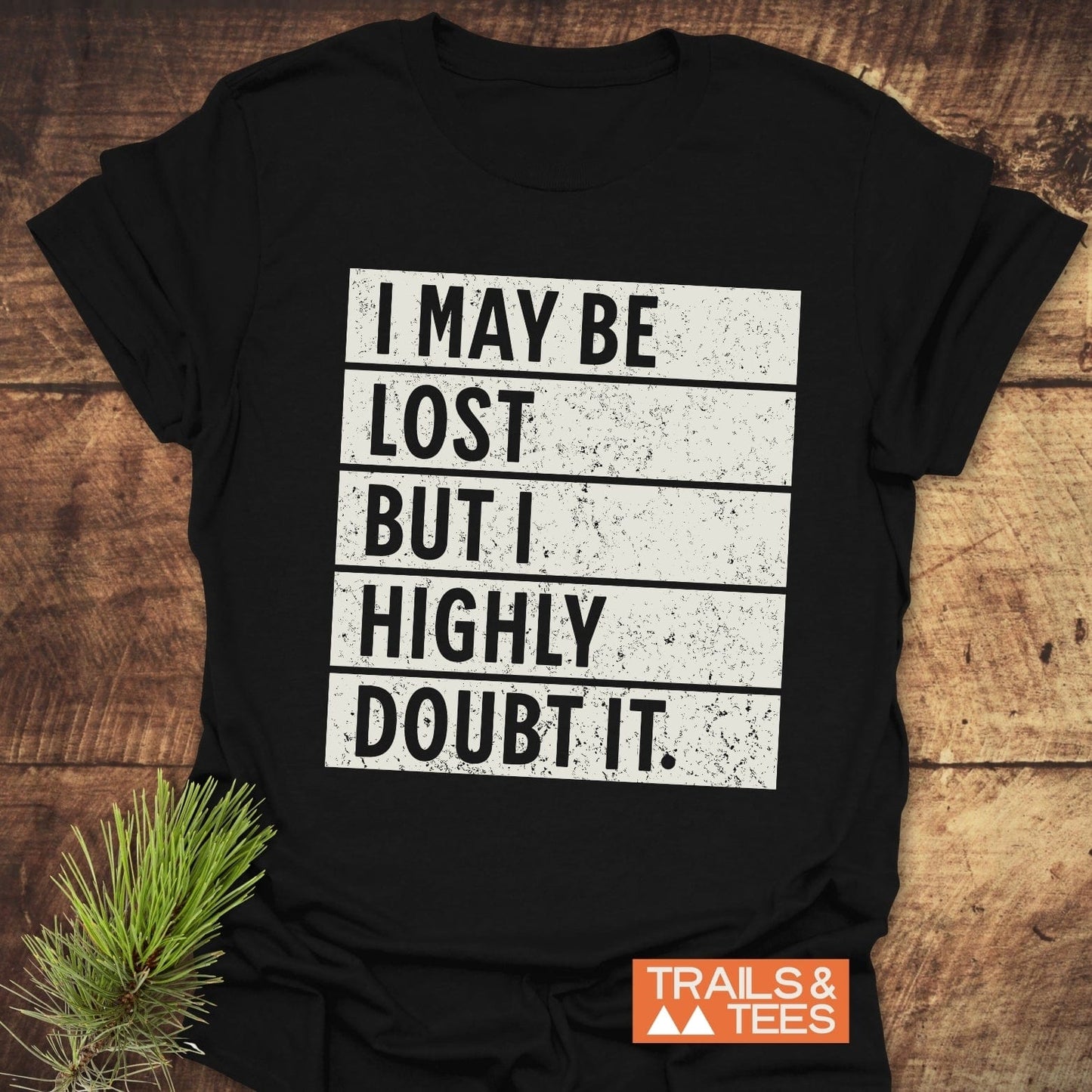 Black shirt with white text reading I May Be Lost But I Highly Doubt It, showcasing the bold statement design of this t-shirt.
