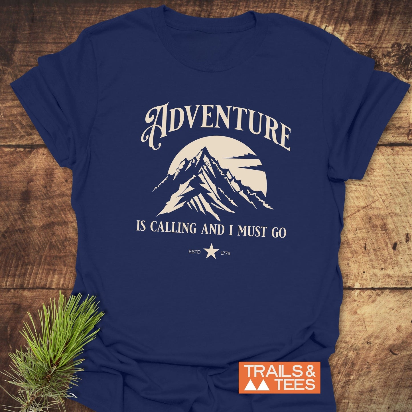 Adventure Is Calling T-Shirt featuring durable white text on a blue shirt, crafted from lightweight cotton for comfort, perfect for outdoor enthusiasts.