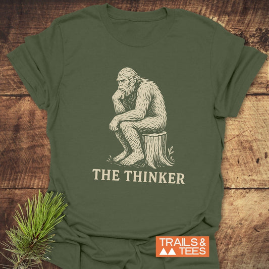 Bigfoot The Thinker T-Shirt featuring a gorilla drawing on a stump, crafted from lightweight ring-spun cotton for comfort and durability.