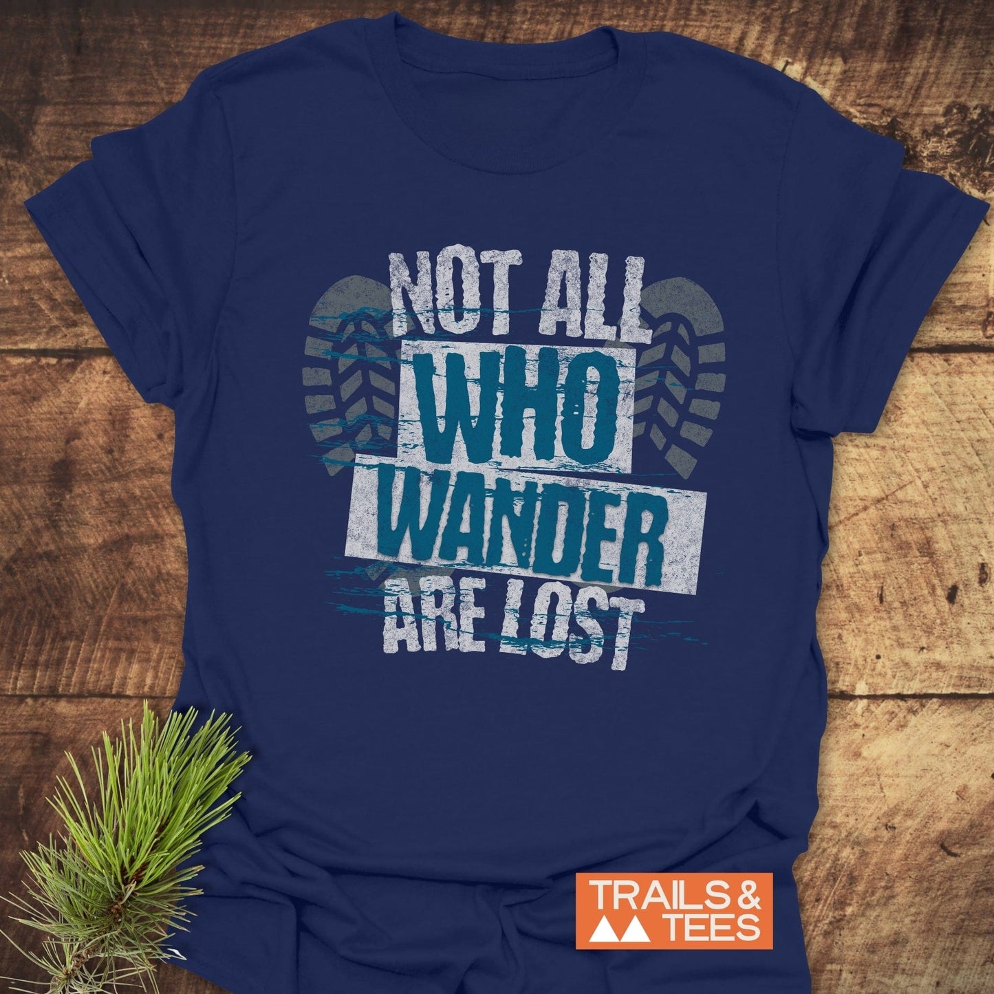 Close-up of a Not All Who Wander Are Lost T-Shirt featuring a detailed tire print design, emphasizing its adventurous theme.