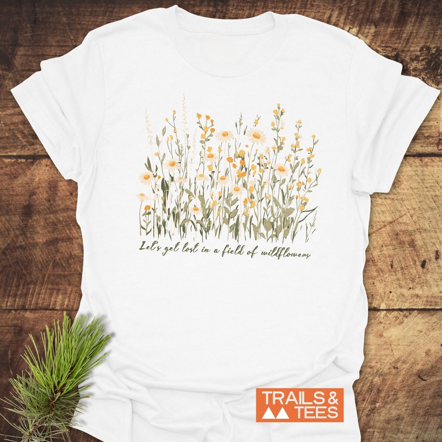 Close-up of 'Let's Get Lost In A Field Of Wildflowers' T-shirt, featuring yellow flower prints on white, crafted from lightweight cotton for adventure-ready comfort.