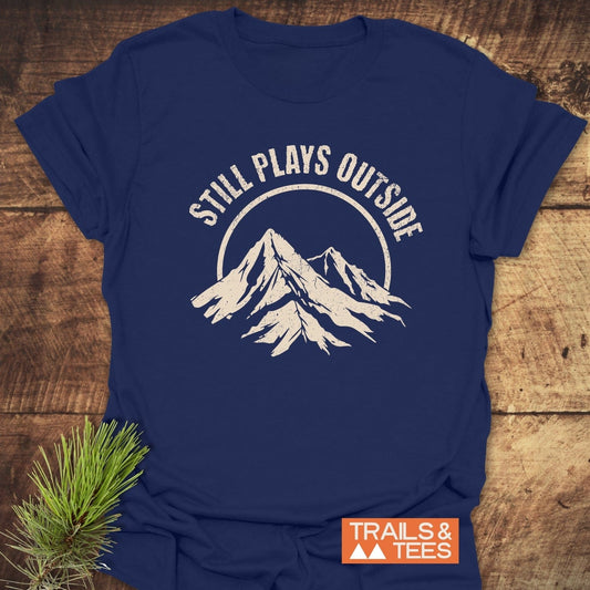 Still Plays Outside T-Shirt featuring durable white text, crafted from soft ring-spun cotton for comfort and adventure-ready durability.