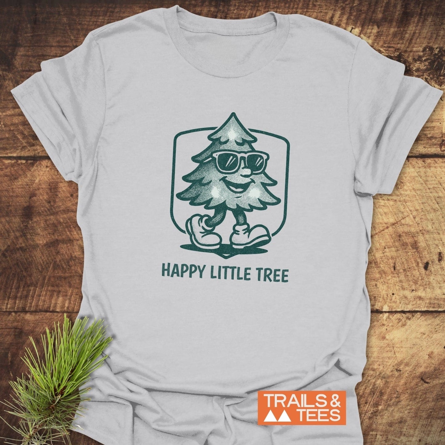 Happy Little Tree T-Shirt featuring a cartoon Christmas tree wearing sunglasses, crafted from lightweight cotton for adventure-ready comfort and durability.