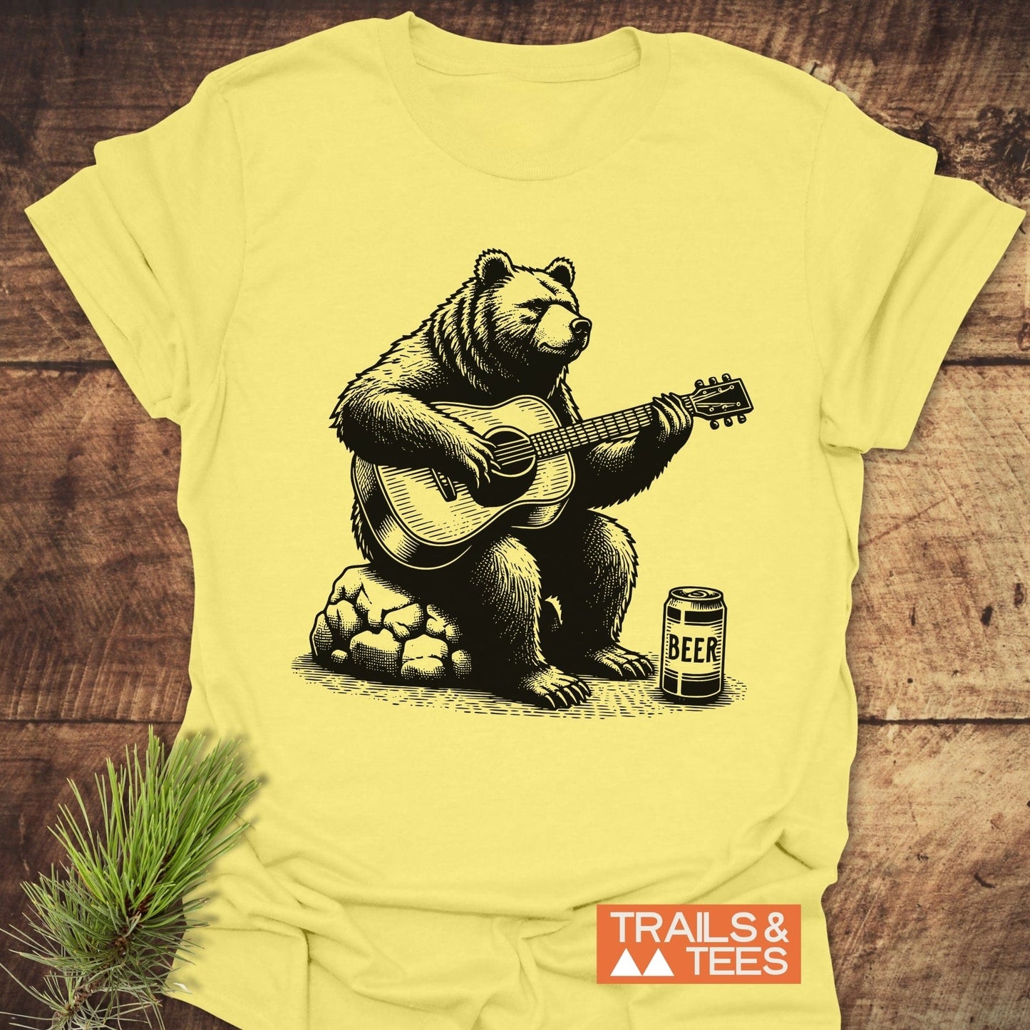 Bear Playing Guitar T-Shirt featuring a whimsical bear illustration strumming a guitar, designed on a casual t-shirt. Perfect for music enthusiasts.