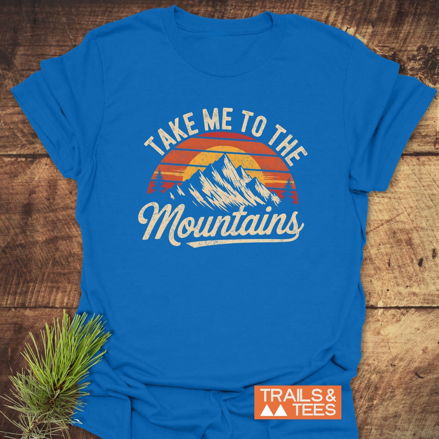 Close-up of 'Take Me To The Mountains' T-Shirt featuring a mountain graphic, ideal for outdoor enthusiasts seeking stylish and active clothing.