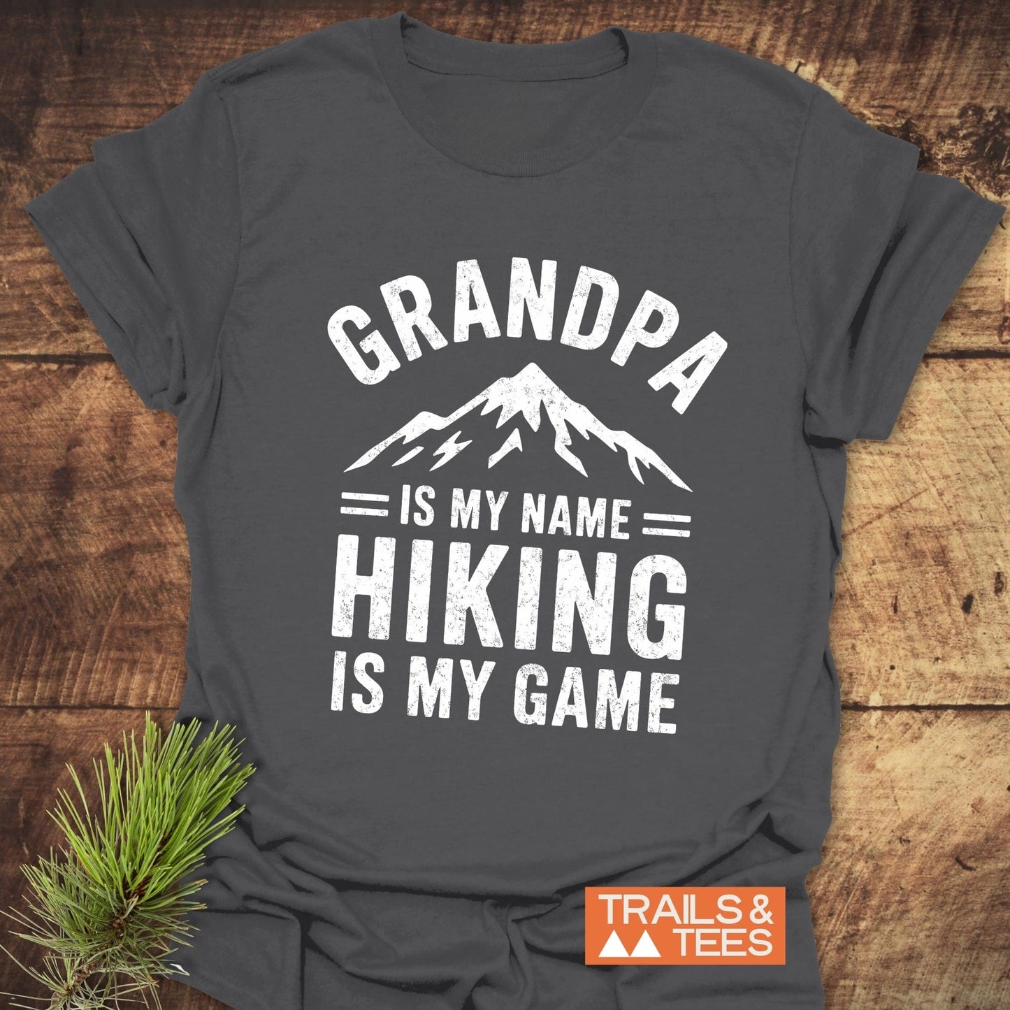 Grey t-shirt featuring the phrase Grandpa Is My Name Hiking Is My Game in white text, ideal for active wear and outdoor enthusiasts.