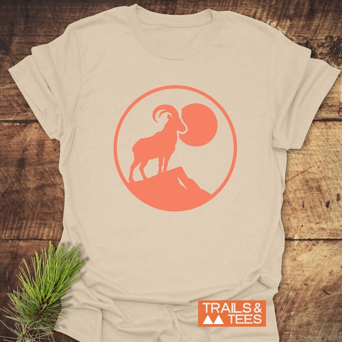 Mountain Goat T-Shirt featuring a goat and pine branch design, crafted from soft ring-spun cotton for comfort and durability, ideal for outdoor enthusiasts.