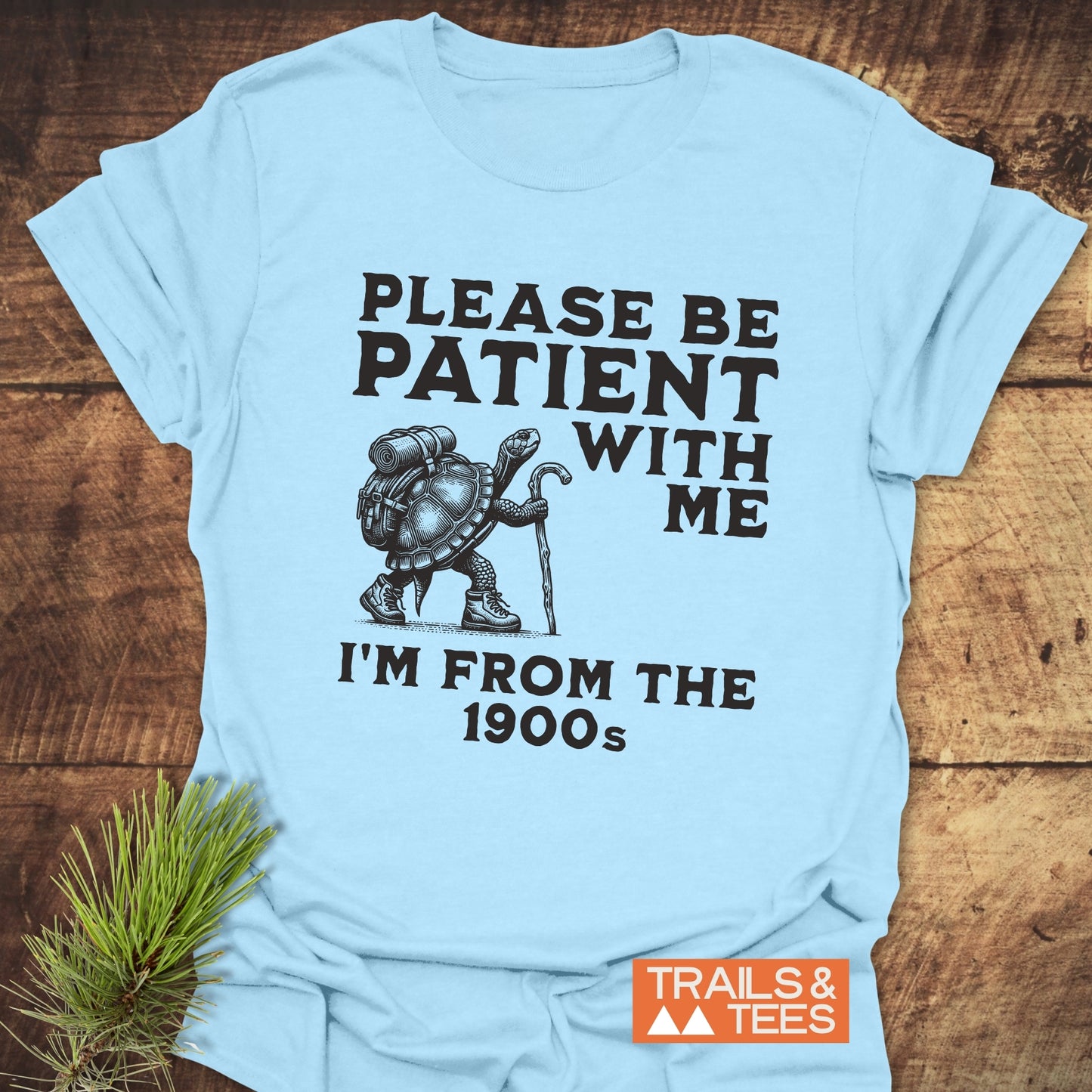Please Be Patient With Me I'm From The 1900s T-Shirt featuring a turtle in hiking gear, printed on the front with Trails & Tees logo.