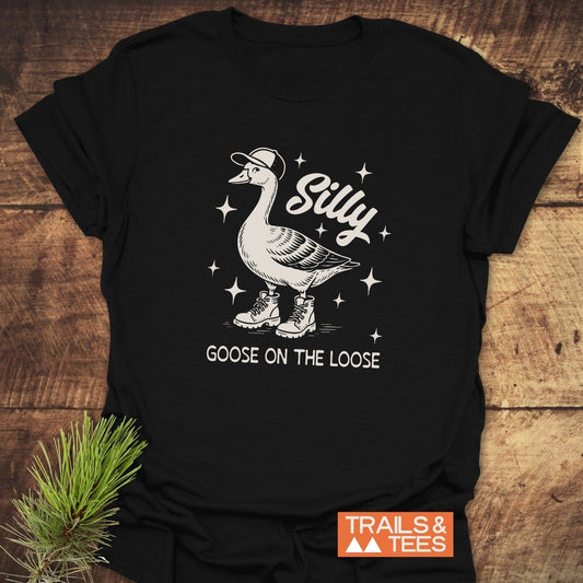 Silly Goose T-Shirt featuring a whimsical goose in a cap and boots, surrounded by sparkles, with Silly above and Goose on the Loose below.