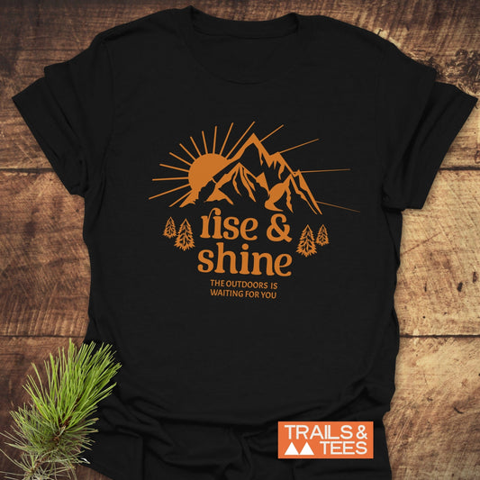 Rise And Shine T-Shirt featuring a sun and mountain print with rise & shine slogan, crafted from soft cotton for outdoor enthusiasts.