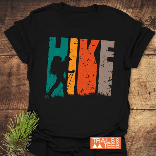HIKE Retro Sunset T-Shirt featuring colorful block-style letters and a backpacker silhouette, crafted from soft cotton for outdoor comfort and adventure.