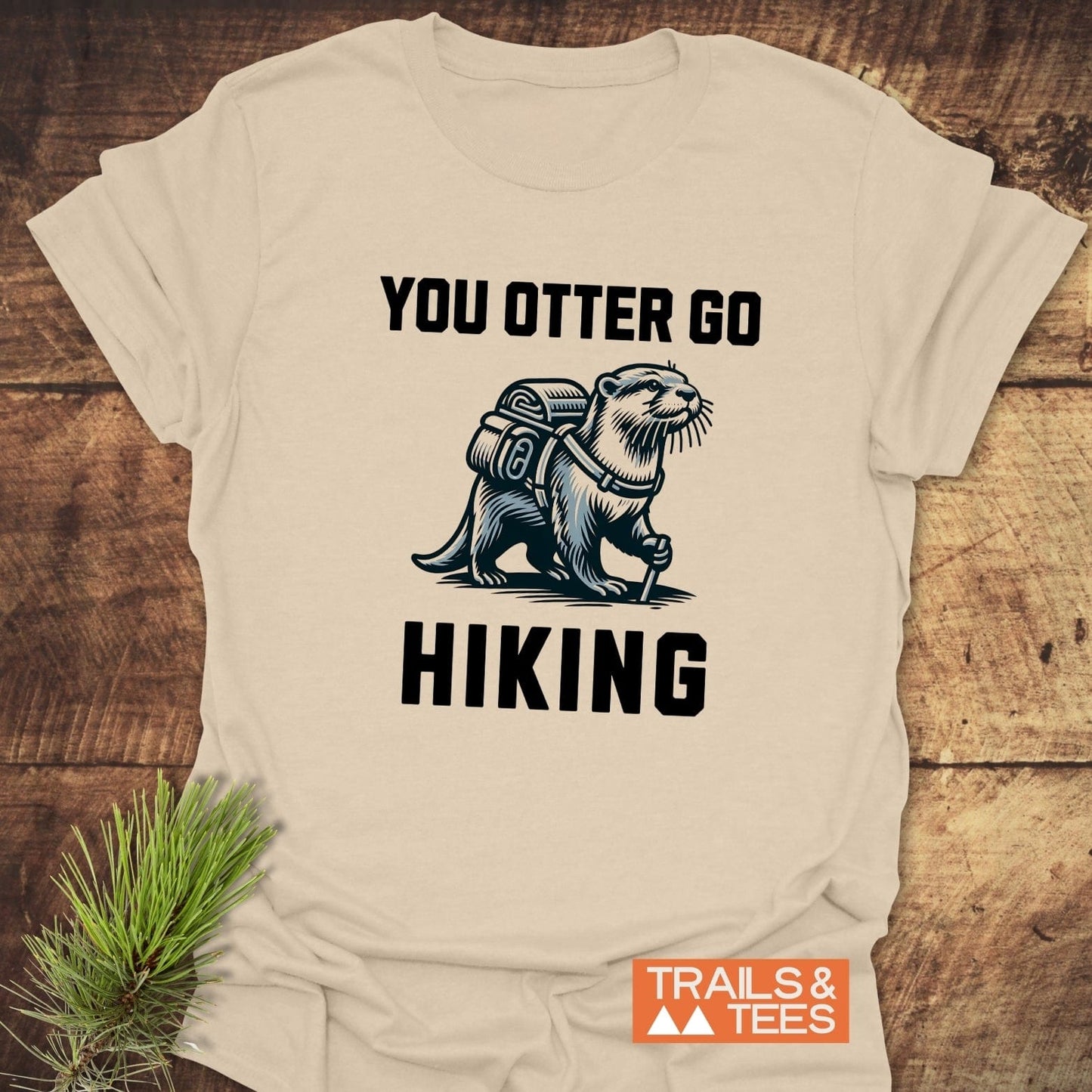 You Otter Go Hiking T-Shirt featuring a cartoon otter with a backpack, crafted from soft cotton for comfort during outdoor adventures.