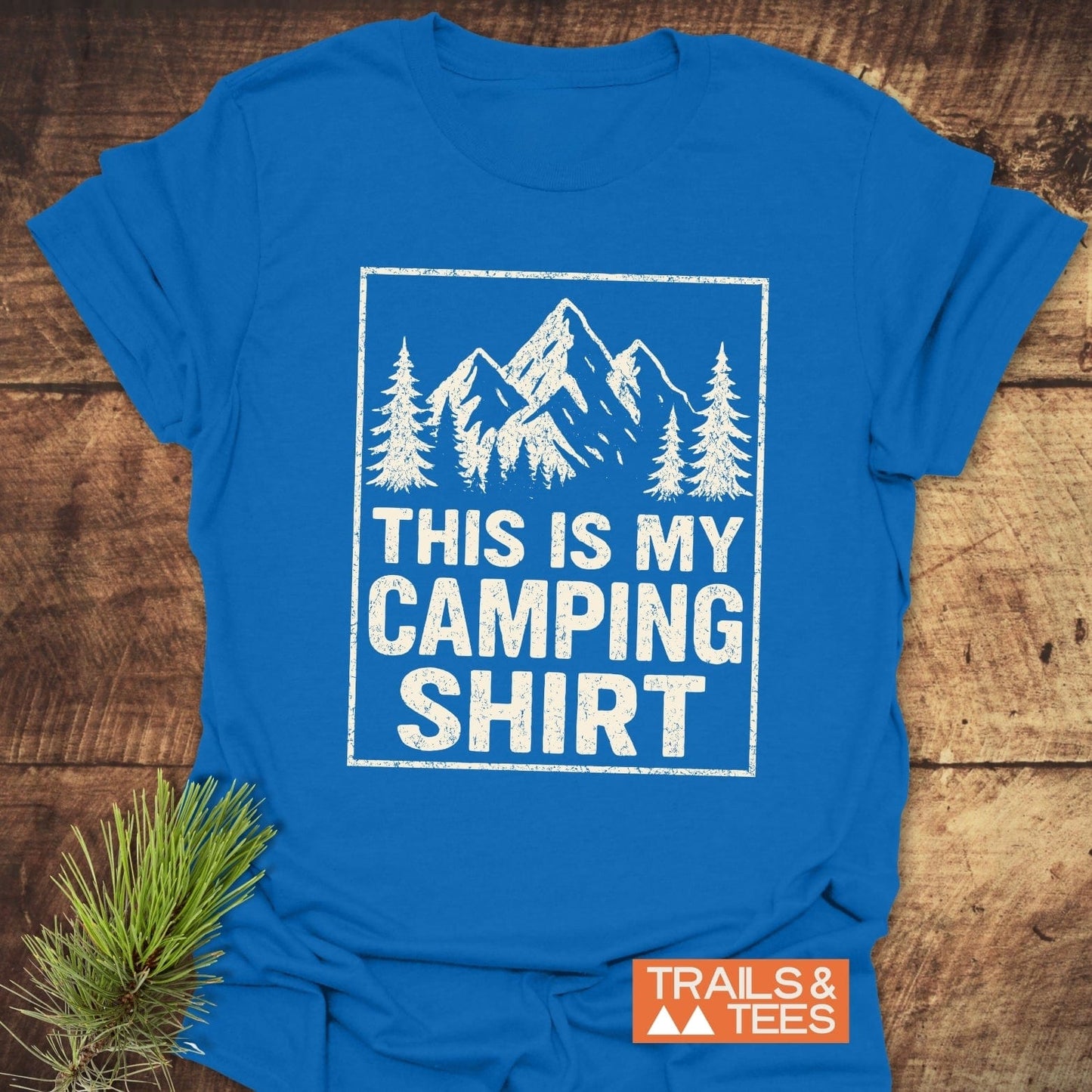 This Is My CAMPING T-Shirt featuring distressed mountain graphic, pine trees, and 'TRAILS & TEES' logo, crafted from soft cotton for outdoor adventures.