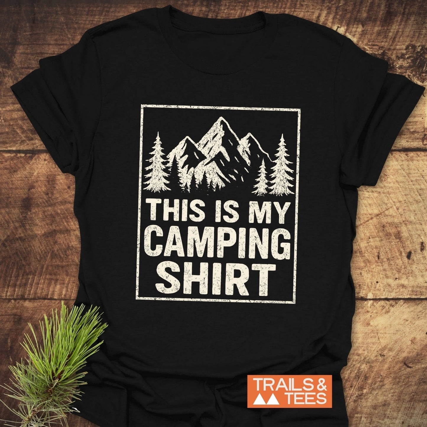 Black T-shirt with white mountain scene and THIS IS MY CAMPING SHIRT text, featuring durable print and soft cotton for outdoor enthusiasts.