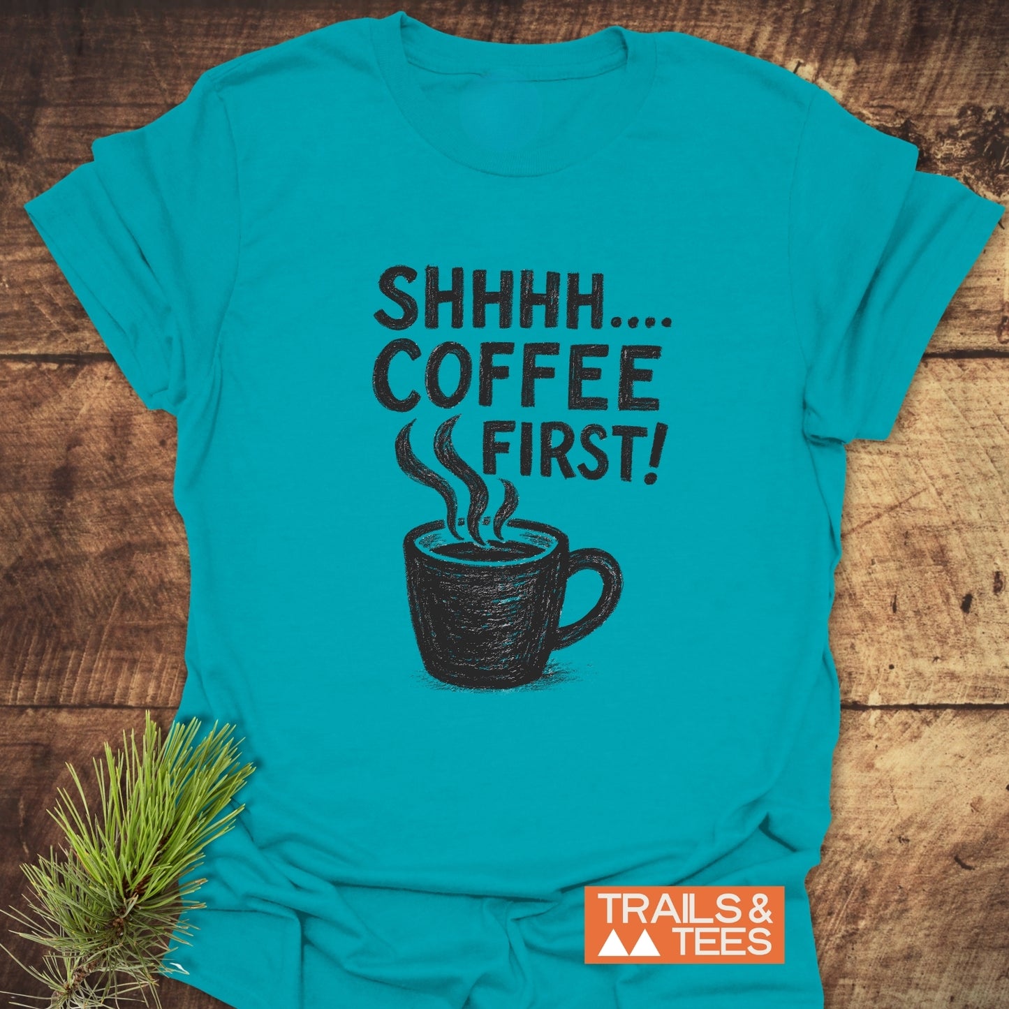 Teal T-shirt with SHHHH… COFFEE FIRST! and coffee mug sketch, featuring Trails & Tees logo. Made from soft, durable cotton.