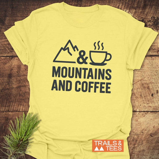 Mountains And Coffee T-Shirt featuring a mountain, ampersand, and coffee cup graphic, with bold text, on soft, lightweight cotton for outdoor enthusiasts.