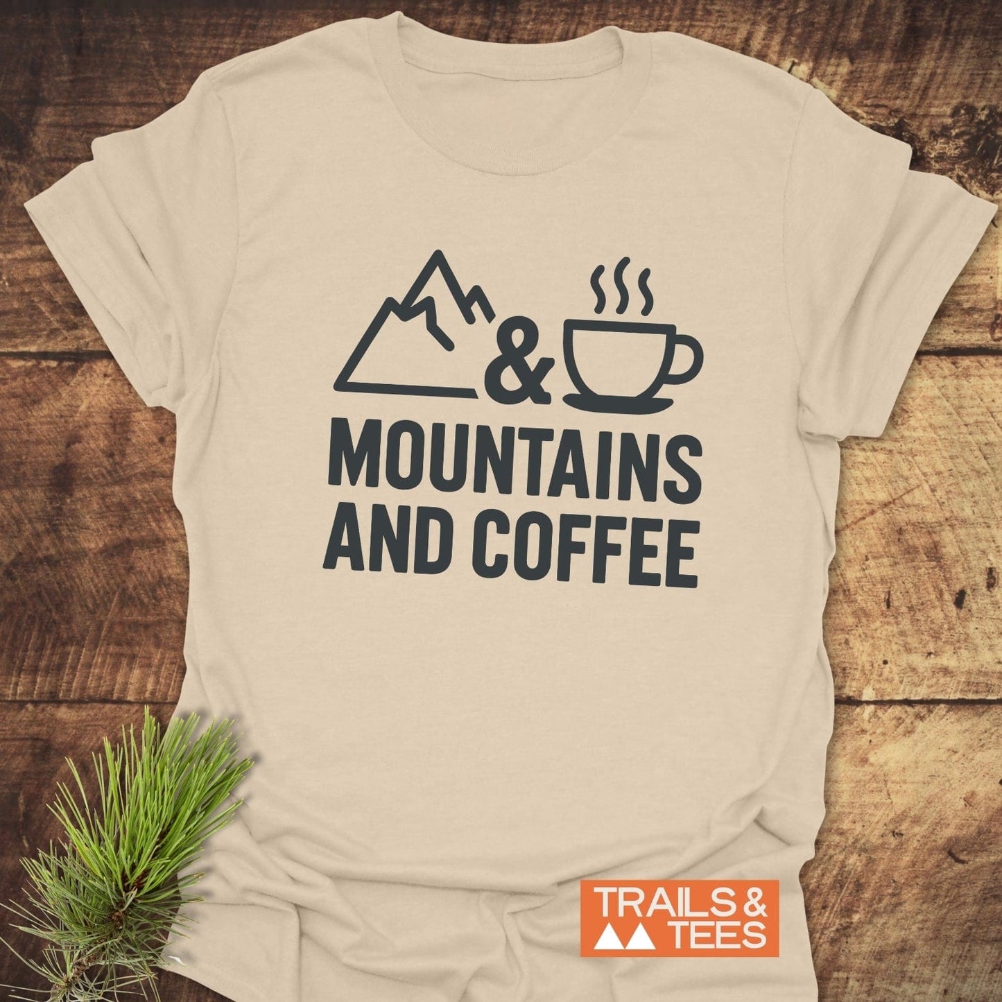 Mountains And Coffee T-Shirt featuring a mountain, ampersand, and coffee cup graphic, showcasing soft, durable cotton perfect for outdoor enthusiasts.