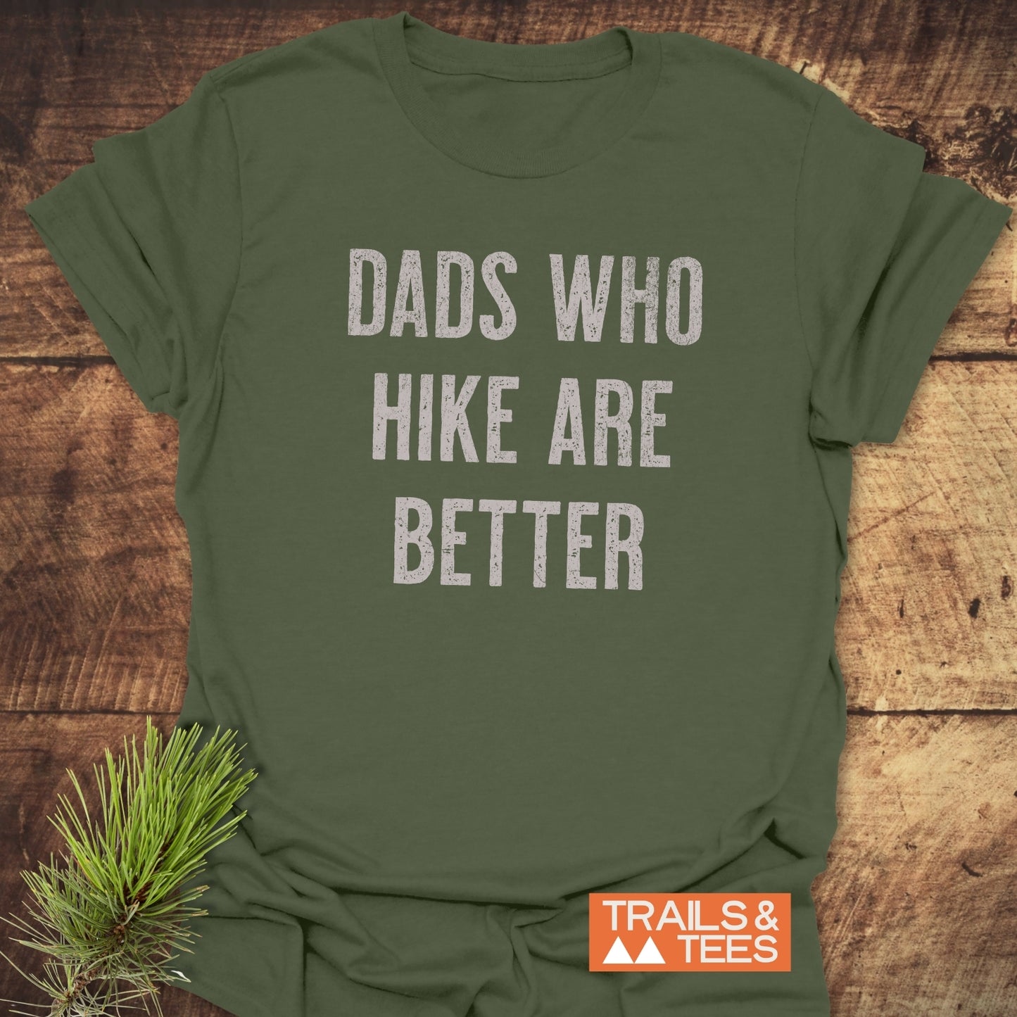 Olive-green Dads Who Hike Are Better T-shirt by Trails & Tees, showcasing durable white lettering, perfect for outdoor enthusiasts.