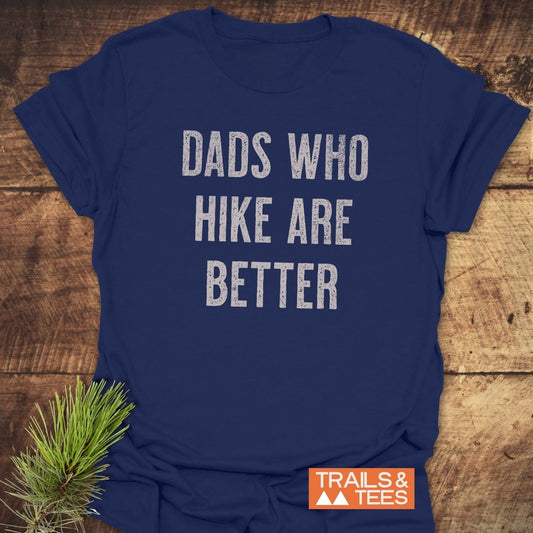 Navy-blue Dads Who Hike Are Better T-shirt with distressed white text, orange logo, and pine sprig. Made from soft, lightweight ring-spun cotton.