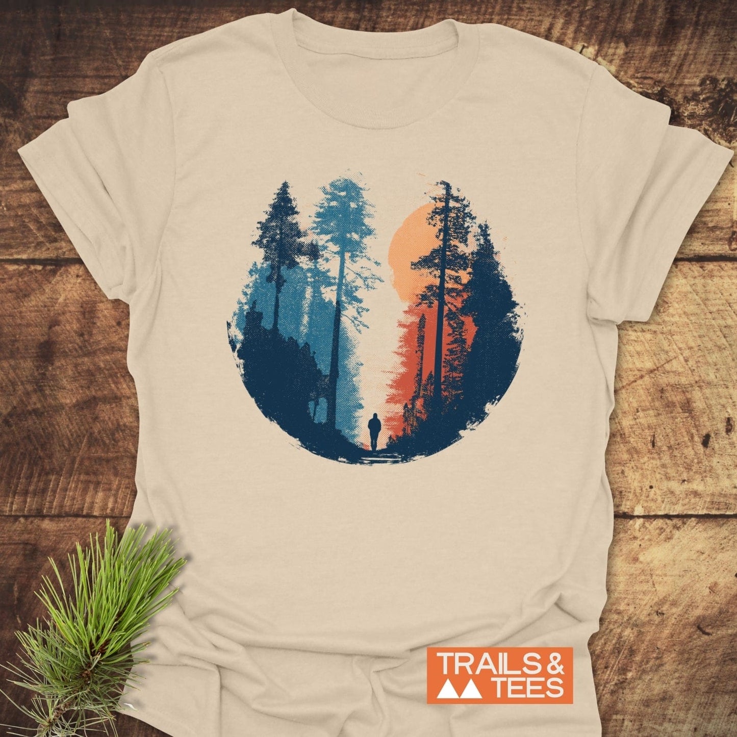 Sunset Hiker T-Shirt with a split-color forest graphic, featuring pine trees and silhouette, on soft, lightweight cotton. Perfect for outdoor enthusiasts.