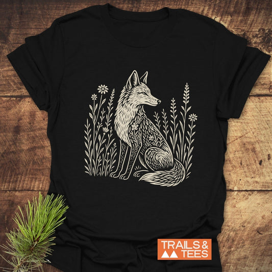 Wildflower Fox T-Shirt with a fox illustration among wildflowers. Crafted from lightweight cotton, it offers comfort and durability for outdoor enthusiasts.