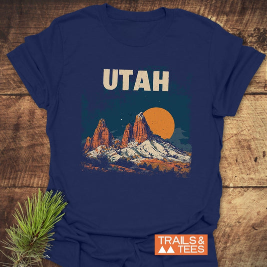 Utah Retro T-Shirt with desert scene and UTAH text, laid on wood. Features durable print, soft cotton, and outdoor-themed design, ideal for adventure lovers.