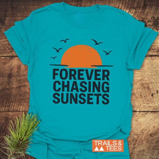 Forever Chasing Sunsets T-Shirt with orange sun graphic and birds, crafted from soft cotton for comfort. Features durable prints and pre-shrunk fit.