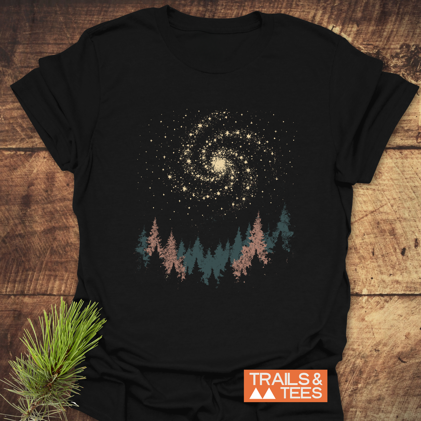 Woodland Nightsky T-Shirt with galaxy and pine tree graphic, showcasing outdoor spirit. Features soft, durable cotton for comfort and adventure.