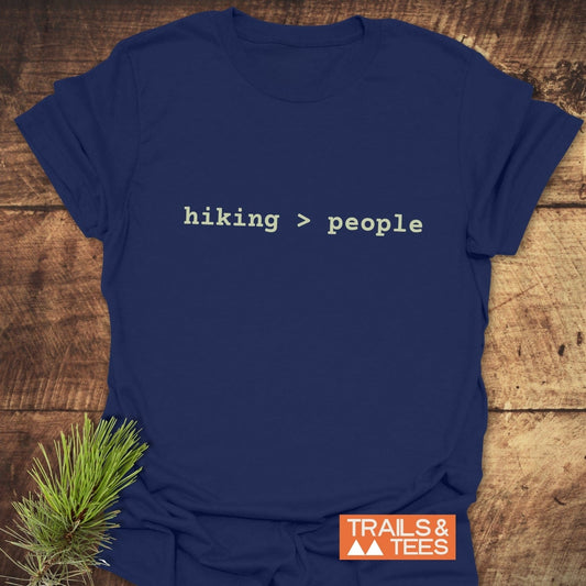 Navy-blue Hiking > People T-shirt, light monospaced slogan, laid on wood with pine sprig. Soft ring-spun cotton for comfort, durable print, pre-shrunk fit.
