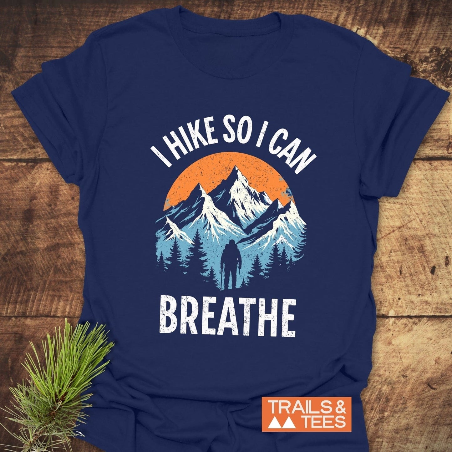 I Hike So I Can Breathe T-Shirt featuring a hiker graphic with mountains and trees, crafted from soft cotton, perfect for outdoor enthusiasts.