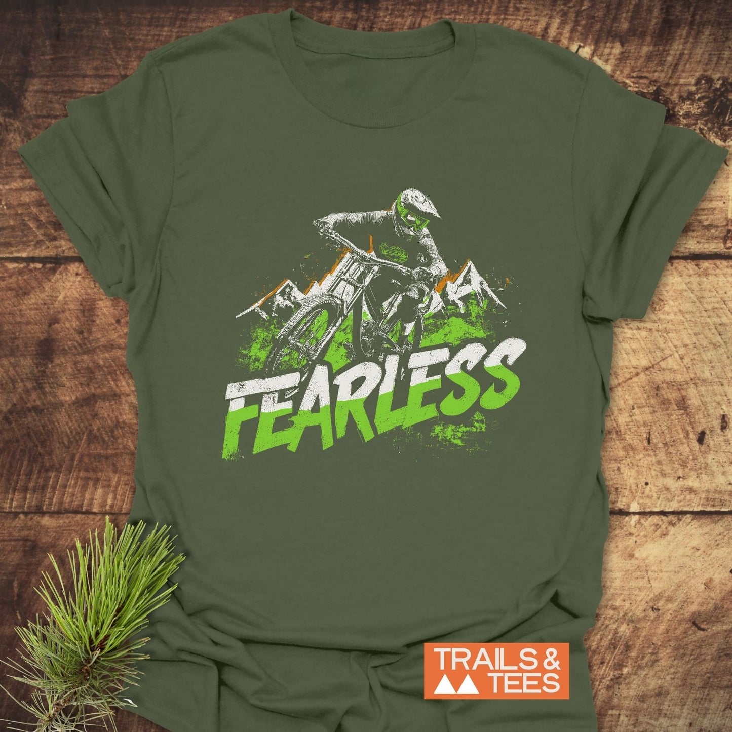 Fearless Mountainbiker T-Shirt featuring a graphic of a downhill biker and FEARLESS text, laid on wood. Crafted from soft, ring-spun cotton for comfort.