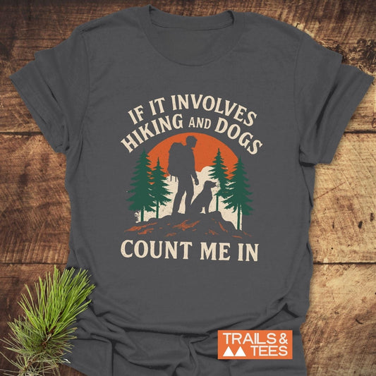 Hiking And Dogs T-Shirt: Dark-gray with a backpacker and dog silhouette against an orange sun, surrounded by pine trees. IF IT INVOLVES HIKING AND DOGS, COUNT ME IN.
