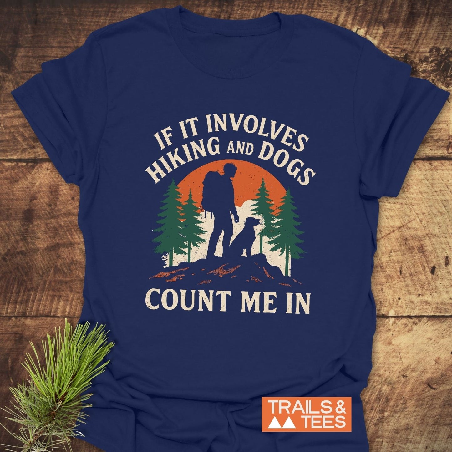 Hiking And Dogs T-Shirt featuring a hiker, dog, and sunset graphic, with slogan. Made from soft cotton with durable print, showcasing outdoor adventure spirit.