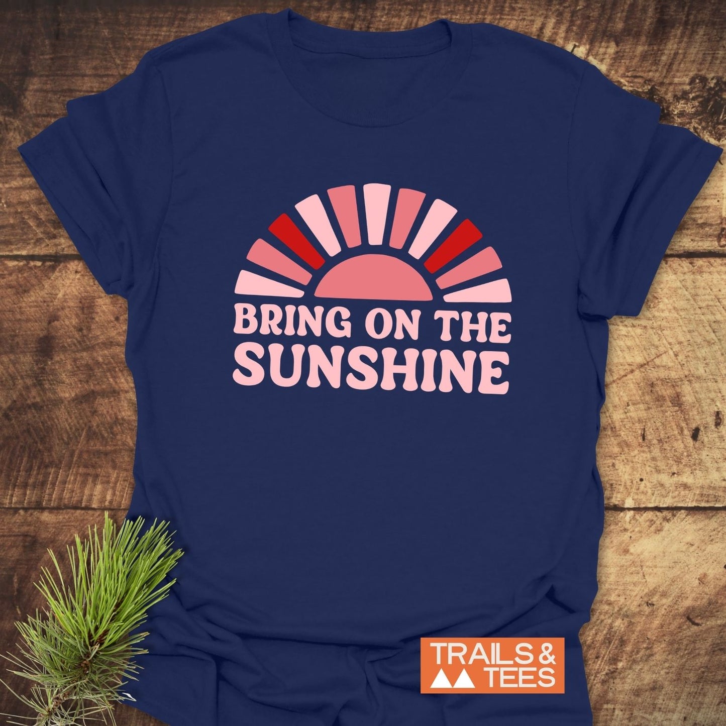 Bring On The Sunshine T-Shirt featuring a half-sun graphic and slogan, crafted from soft ring-spun cotton with durable prints, styled with a pine sprig.