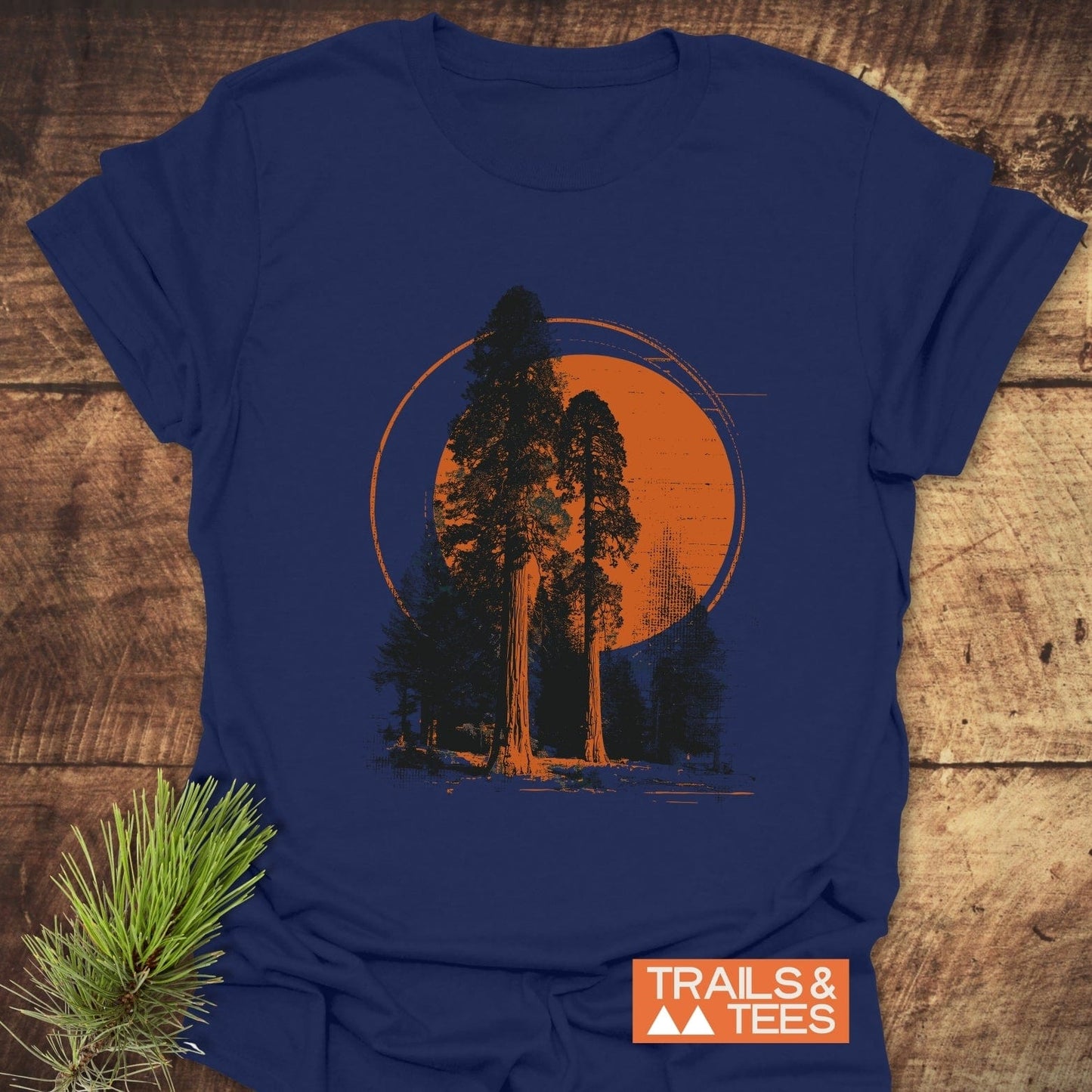 Sequoia T-Shirt featuring a graphic of silhouetted trees against an orange circle, symbolizing nature. Made from soft ring-spun cotton for outdoor comfort.