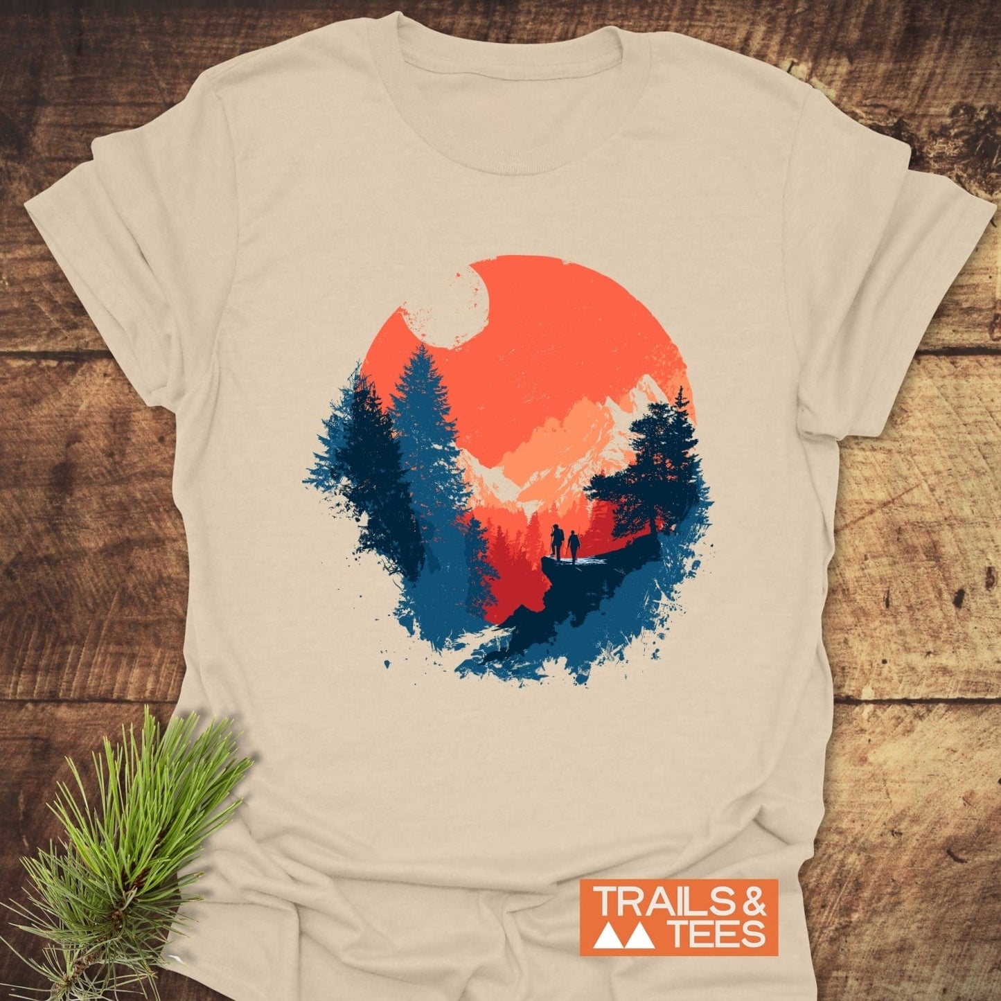 Sunset Hiking T-Shirt featuring a vibrant landscape graphic with sun, mountains, and hikers, on soft, lightweight cotton, showcasing outdoor adventure and comfort.